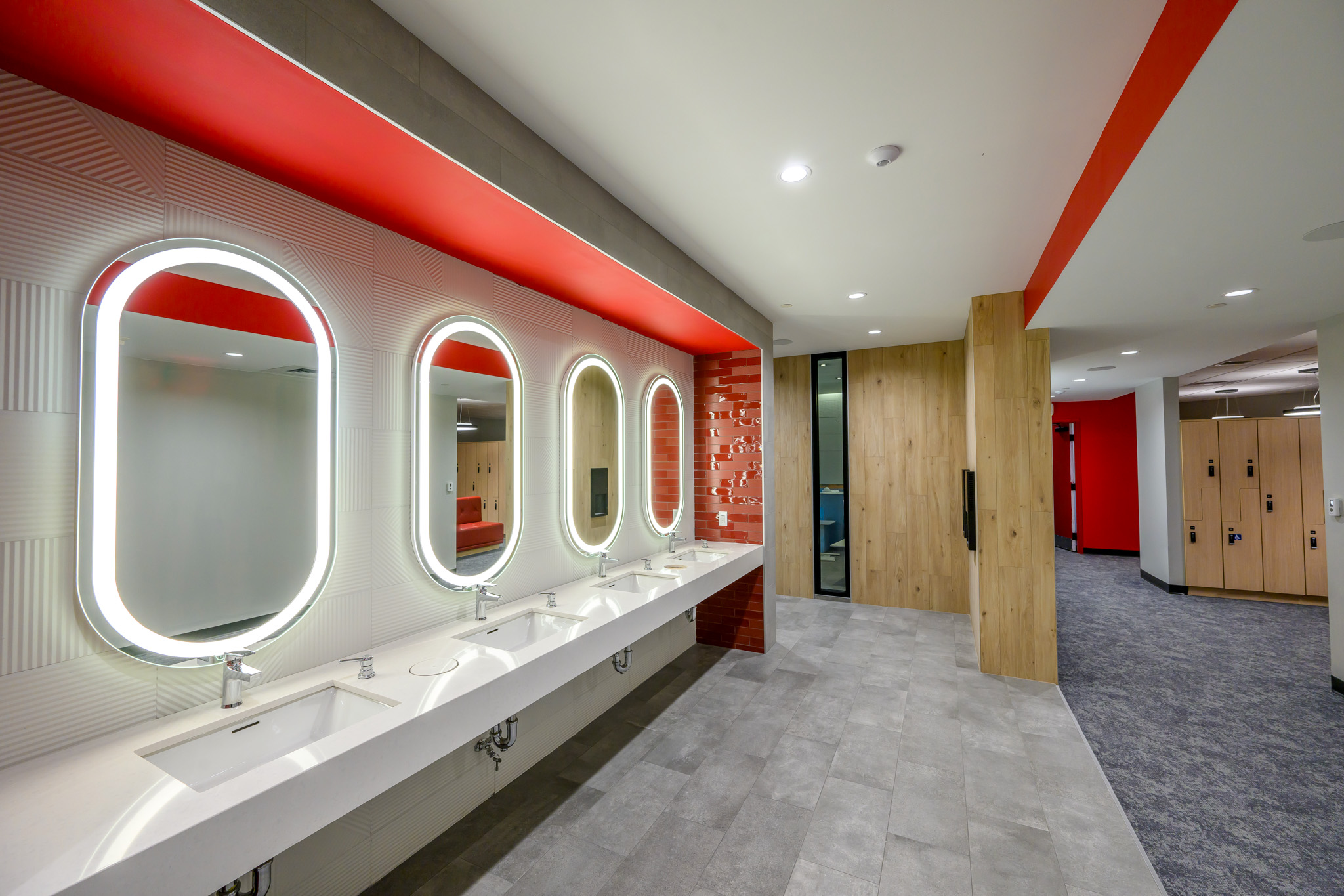 Bosse locker room equipped with brightly lit mirrors, lockers, and bathrooms.