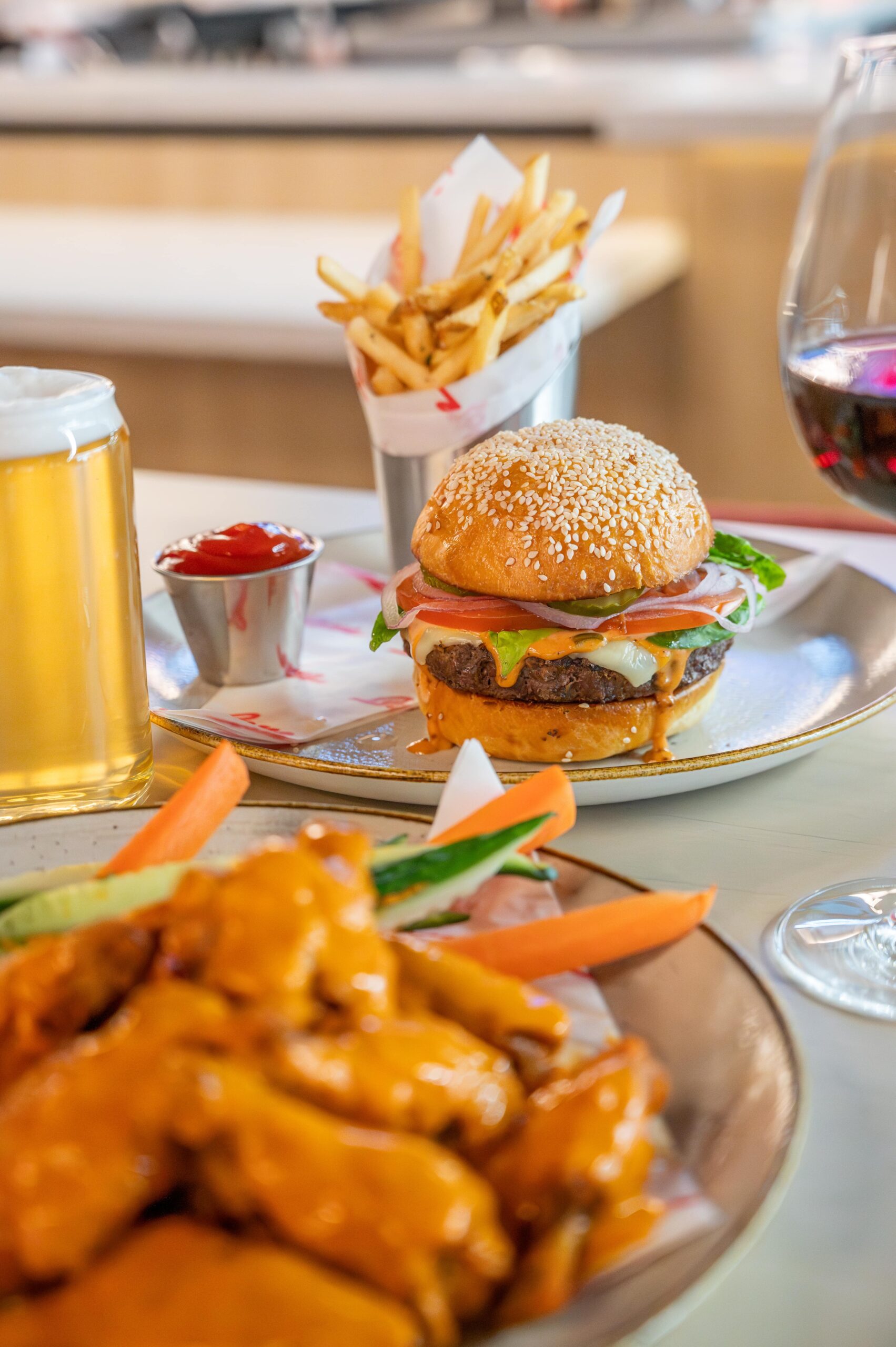 Delicious display of burgers, fries, beer, and chicken wings.