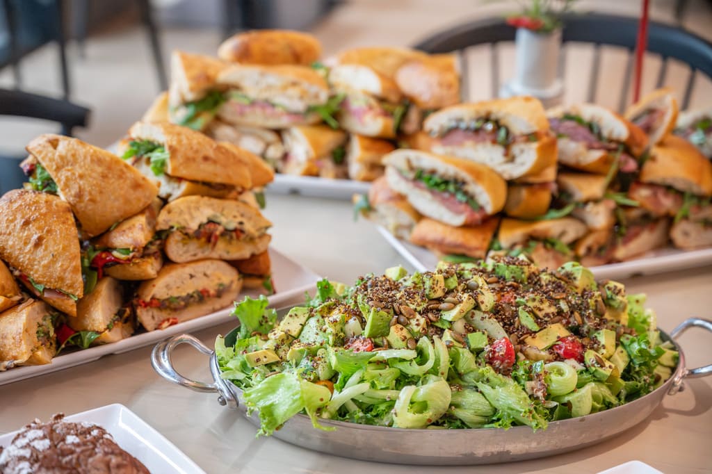 Assorted gourmet sandwiches and fresh green salad with avocado